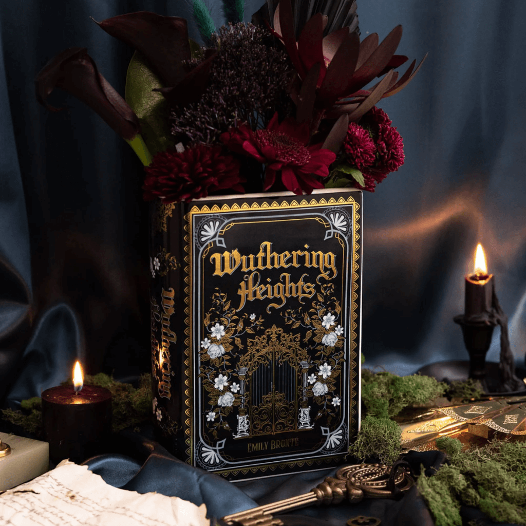 Close-up styled photo of Wuthering Heights ceramic book vase used as a flower vase with candlelight