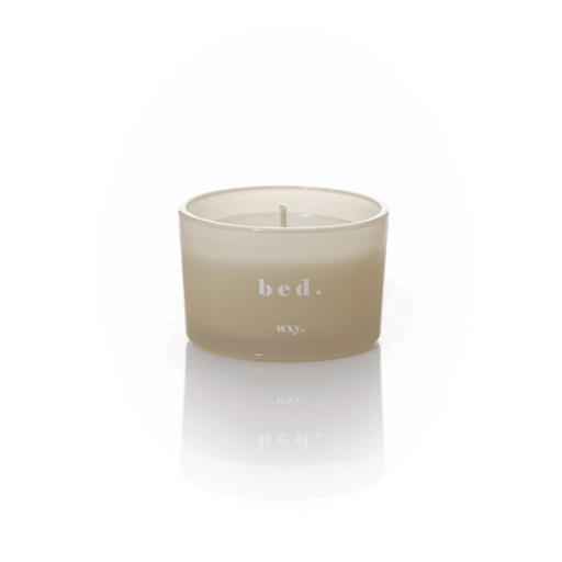 Frosted pale grey glass WXY bed candle with white wax and a centred wick on a white background.