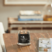 Yankee Candle Midsummer's Night medium Signature jar scented candle lit on a wooden table, dark wax lifestyle image