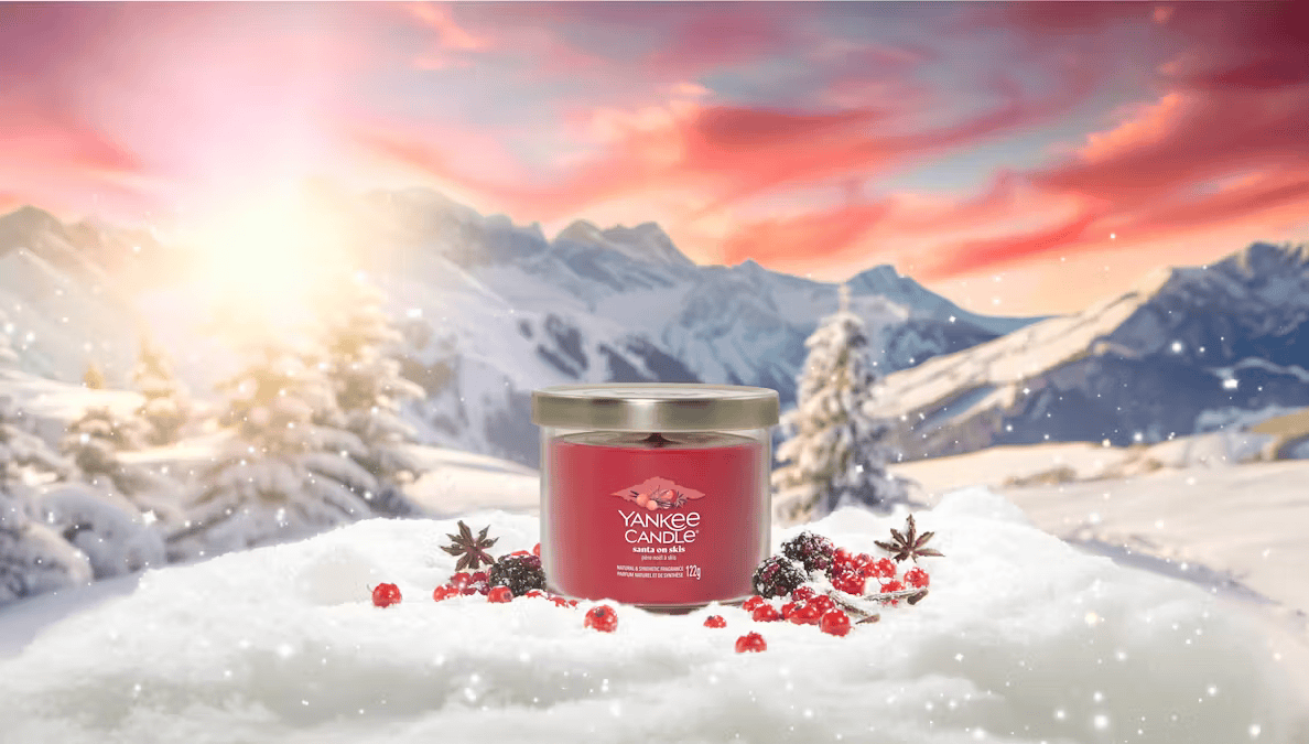 Santa on Skis candle on snowy mountain scene with red berries and star anise
