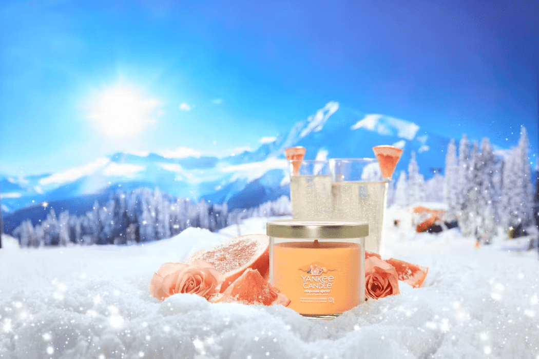 Slopeside Spritz candle on snowy alpine scene with grapefruit, fizz and roses