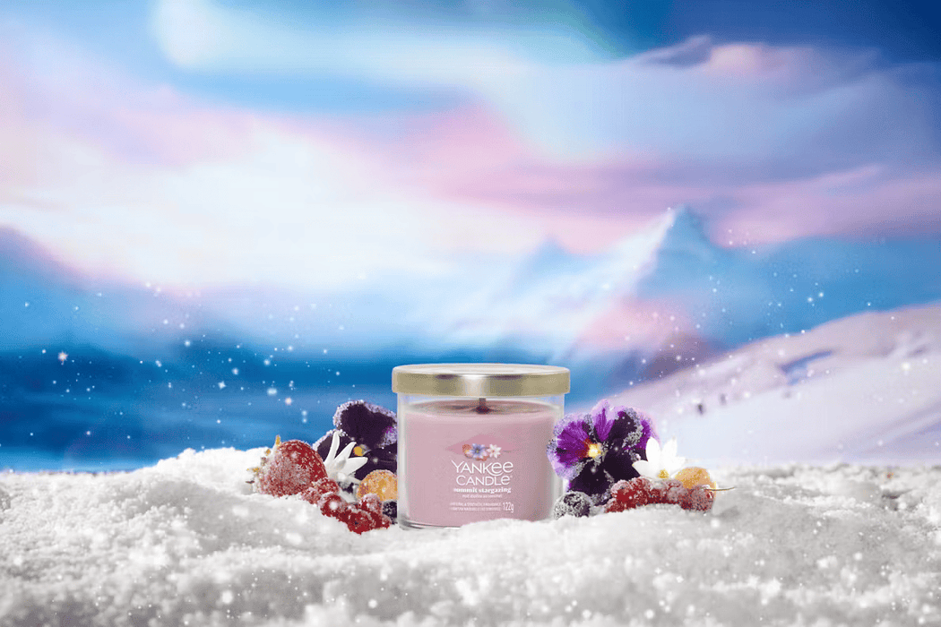 Summit Stargazing candle on snowy scene with frosted berries and flowers, mountain sky backdrop